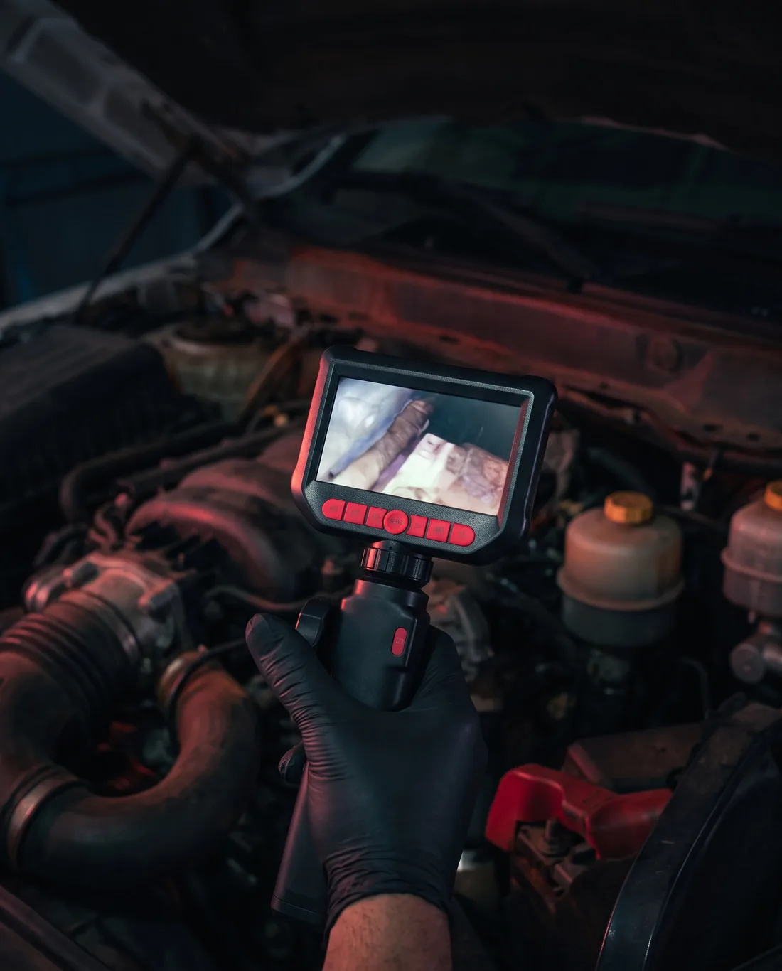 Técnico da TS usando boroscópio, com a tela mostrando o interior do motor